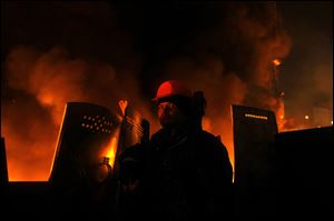 An anti-government protester mans a barricade at Independence Square in Kiev, Ukraine, Thursday.