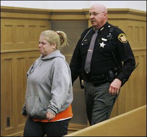 Rebecca Steinmiller is escorted from a Wood County courtroom after Common Pleas Judge Robert Pollex sentenced her Thursday to three years in prison on a charge of endangering children.
