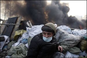 An anti-government protester mans a barricade at Independence Square in Kiev, Ukraine, today.