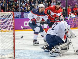 Canada’s Jamie Benn, right, gets his stick on the puck and deflects it past U.S. goaltender Jonathan Quick during the second period of a hockey semifinal on Friday. It was the only goal of the game.