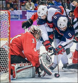 U.S. forwards Zach Parise, right, and Ryan Kesler try to score against Canada goaltender Carey Price during the first period on Friday. Price made 30 saves to backstop the Canadians to the win.