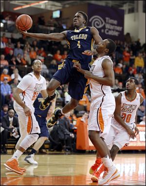 University of Toledo guard Justin Drummond (4) goes to the basket against Bowling Green State University  forward Spencer Parker (3).