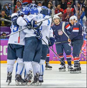 The U.S.’s Justin Faulk and Joe Pavelski react as Finland celebrates a goal during the third period of the men's bronze medal hockey game.