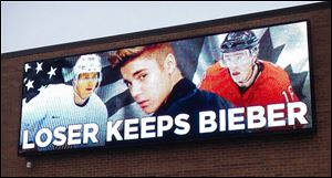 An electronic billboard displays pop star Justin Bieber, center, sandwiched by Chicago Blackhawks stars Patrick Kane, left, and Jonathan Toews outside the Skokie, Ill.