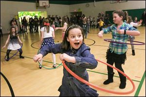 Eleanor Kelso, 9, center, laughs with a classmate as she almost drops her hula hoop during a dance party at Sylvan Elementary School in Sylvania. Enrollment runs from kindergarten to fifth grade.
