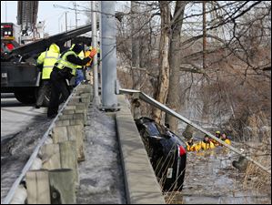 Workers remove a car from Otter Creek in Oregon, today. The Chevrolet Impala went through a guard rail on Otter Creek Road near Millard Avenue, into the creek below.  The female driver of the vehicle died.