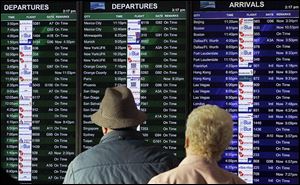 Passengers look at the arrivals and departures board at the international terminal at San Francisco International Airport. CheapAir.com advises being flexible to avoid the most popular travel days.