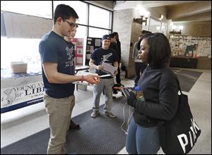 Ron Johns, 21, president of the University of Toledo chapter of the Young Americans for Liberty, hands a fake cigarette to fellow student Marshae Foy, 20, of Cleveland at UT’s student union.