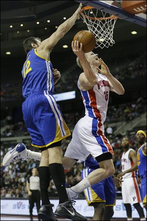 Detroit Pistons forward Kyle Singler (25) shoots while defended by Golden State Warriors center Andrew Bogut (12).