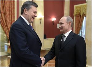 Russian President Vladimir Putin, right, shakes hands with Ukrainian President Viktor Yanukovych at the Olympic reception hosted by the Russian President in Sochi, Russia on Feb. 7.