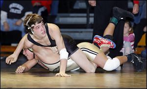 Delta’s Jake Spiess checks the time against Perrysburg’s Moises Guillen at the Perrysburg Invitational Tournament. Spiess is 45-0 at 113 pounds. He was a state champion last season at 106.