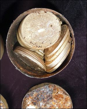 This image provided by the Saddle Ridge Hoard discoverers via Kagin's, Inc., shows one of the six decaying metal canisters filled with 1800s-era U.S. gold coins unearthed in California.