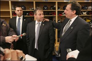 Nick Vitucci, center, is embraced by Walleye president and general manager Joe Napoli, right, after announcing his resignation as head coach while the pair address the media on Tuesday. Dan Watson, left, will take over as interim head coach.