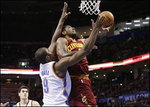 Cleveland Cavaliers guard Kyrie Irving (2) shoots in front of Oklahoma City Thunder forward Serge Ibaka (9).