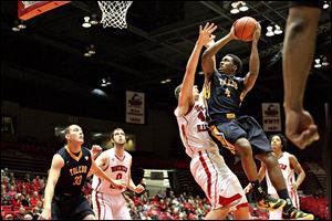 Toledo's Justin Drummond shoots the ball iover Northern Illinois’ Jordan Threloff in the first half. Drummond finished with nine points in the loss to the 13-14 Huskies. The Rockets fell to 23-5, 11-4 in the MAC. 