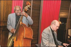 Clifford Murphy plays the bass at his 82nd birthday party at the Toledo Club.