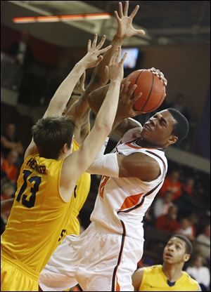 BGSU’s Richaun Holmes attempts to shoot over Kent State’s Mark Henniger on Wednesday night. Holmes scored 14 points.