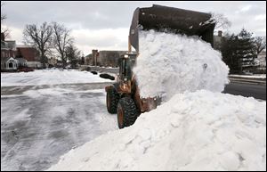 Paul Voska adds to an ever-growing pile of snow from the parking lot of the Toledo History Museum, 2001 Collingwood Blvd. in Toledo. 