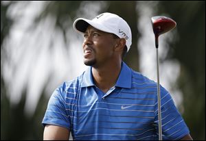 Golfer Tiger Woods watches his tee shot on the 18th hole during the first round of the Honda Classic golf tournament, today in Palm Beach Gardens, Fla. ASSOCIATED PRESS