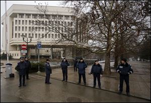 Ukrainian police officers guard street in front of a local government building in Simferopol, Crimea, Ukraine, today. Ukraine put its police on high alert after dozens of armed pro-Russia men stormed and seized local government buildings in Ukraine's Crimea region early today and raised a Russian flag over a barricade.