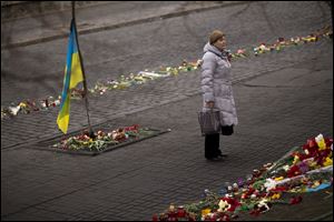 A woman stands at a memorial for the people killed in clashes with the police at Kiev's Independence Square.