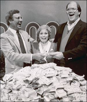 Host Jim Lange, left, congratulates Connie and Steve Rutenbar of Mission Viejo, Calif., after they won $1 million on the TV show 