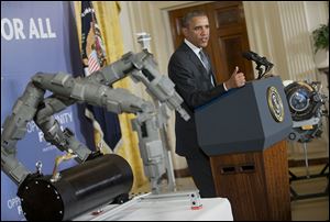 Beside a set of robotic arms, President Obama spoke about manufacturing innovation institutes last week at the White House.