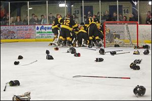 The Northview hockey team piles on goalie David Marsh in celebration after clinching a third-straight district title over St. John’s on Saturday. Marsh had 23 saves for the Wildcats.