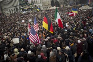Protesters holding U.S., German and Italian flags arrive at Independence Square during a rally Sunday in Kiev.