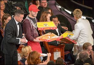 Brad Pitt, left, and Oscar host Ellen DeGeneres, right, pass out pizza in the audience during the Oscars.