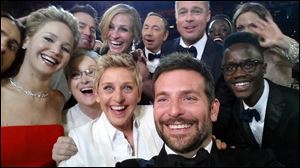This image released by Ellen DeGeneres shows actors front row from left, Jennifer Lawrence, Meryl Streep, DeGeneres, Bradley Cooper, Peter Nyong’o, Jr., and, second row, from left, Channing Tatum, Julia Roberts, Kevin Spacey, Brad Pitt, Lupita Nyong’o and Angelina Jolie as they pose for a selfie during the Oscars. The popular posting crashed Twitter for a few minutes on Sunday.