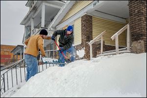 Brian Stewart, left, and John Ashman clear the walkway of a home on Lagrange Street. Mr. Ashman says he appreciates the fresh blanket of snow because it allows the pair to make some money plowing driveways and clearing walks. So it’s time to issue yet another ‘snirt’ alert. ‘Snirt,’ a combination of snow and dirt, is that crusty, dusty, yucky-looking stuff along the edges of highways and byways.