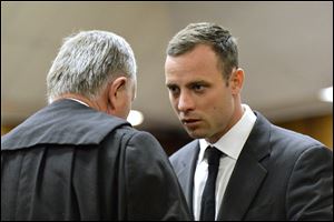 Oscar Pistorius, right, speaks with his lawyer Barry Roux as the start of his trial is delayed at the high court in Pretoria, South Africa, today, March 3, 2014. Pistorius is charged with murder with premeditation in the 2013 shooting death of girlfriend Reeva Steenkamp.
