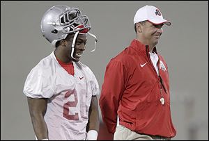 Ohio State coach Urban Meyer, right, laughs with cornerback Armani Reeves during the Buckeyes’ first practice of spring.