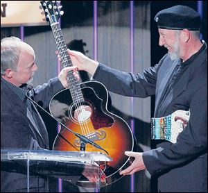 Richard Thompson, right, receives a Gibson guitar from Dave Berryman, president of the guitar company, after being awarded the Lifetime achievement Songwriting Award in Nashville in 2012.