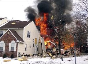 In this image provided by Josh Forst, flames and smoke shoot up after an explosion at a townhouse complex Tuesday.
