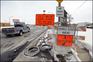 Signs warn of the Anthony Wayne Bridge’s closure for ex­ten­sive re­pairs and ren­o­va­tion, a project that will begin March 17 and continue for 19 months.