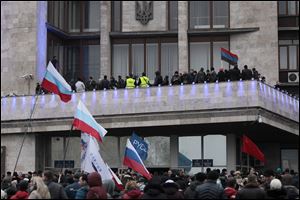 Demonstrators hold Russian flags during a rally in front of the regional administrative building after storming it in Donetsk, Ukraine. The United States and its European allies have agreed to send more money to Ukraine.