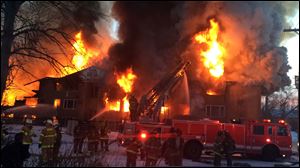 Firefighters battle a four-alarm fire at a three-story apartment complex Wednesday morning on Detroit's west side. 