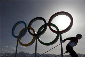 A skier passes by the Olympic rings at the 2014 Winter Olympics, in Krasnaya Polyana, Russia in February.