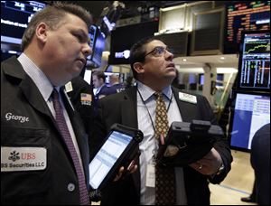 Traders George Ettinger, left, and Robert Oswald work on the floor of the New York Stock Exchange today.