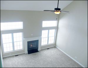 Transoms over generous windows flank the gas fireplace in this two-story great room.