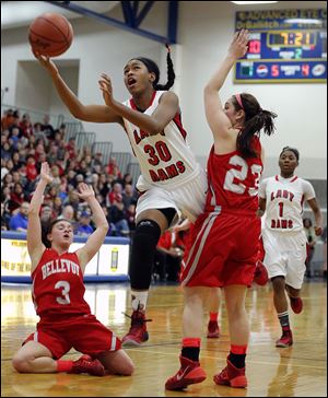 Rogers' Akienrah Johnson, who had nine points,  goes between Bellevue’s Whitney Schalk, left, and Jenna Strayer for a shot.