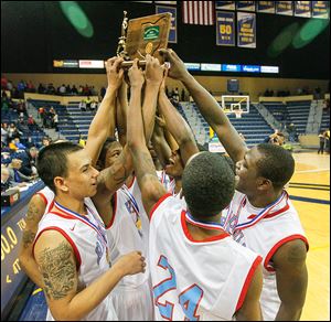 Bowsher players celebrate with their district championship trophy after defeating St. John's at the University of Toledo’s Savage Arena. The win gave the Rebels their first district title in school history.