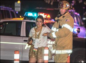 A firefighter assists an injured student after a stage collapsed during a school event at Servite High School in Anaheim, Calif., Saturday. Authorities said dozens were taken to hospitals with minor injuries in what one official deemed a ‘weight issue.’ 