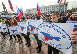 Pro-Russian supporters hold banners during a rally in Simferopol, Crimea. The protesters gathered in  Lenin Square on Sunday to urge a ‘Yes’ vote on the referendum next week on Crimea joining the Russian Federation.