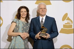 Edie Brickell, left, and Steve Martin in the press room with the award for best American roots song, 