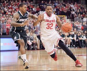 Ohio State's Lenzelle Smith, Jr., right, drives to the basket against Michigan State's Keith Appling. Smith struggled with his shooting but still contributed nine points in the Buckeyes’ win.