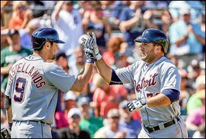 The Tigers' Tyler Collins, right, high-fives teammate Nick Castellanos after hitting a home run in the seventh inning. 