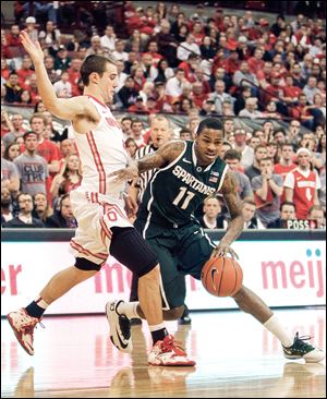 Ohio State’s Aaron Craft makes life difficult for Michigan State's Keith Appling in the first half. The Findlay native and Buckeyes senior set the Big Ten mark for career steals in the win on Sunday.